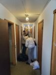 A person handling bags in a hallway.