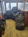 Large bags piled beside windows in a room.