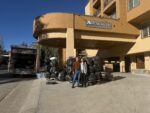People standing beside a moving truck outside a lodge.
